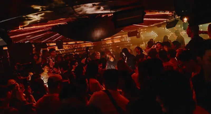 Mirrored copper ceiling and crowd at Astrix Saigon